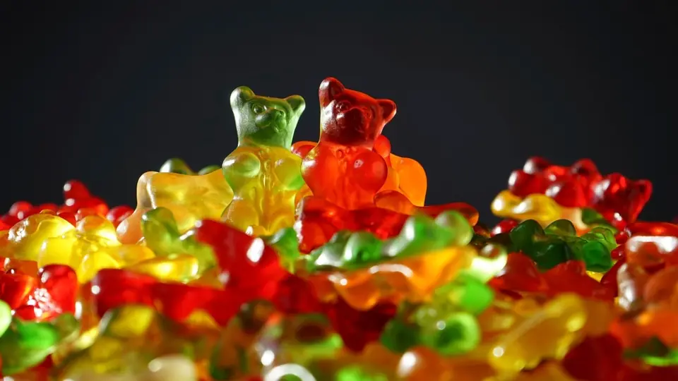 Glänzende Gummibärchen auf einem Haufen vor dunklem Hintergrund