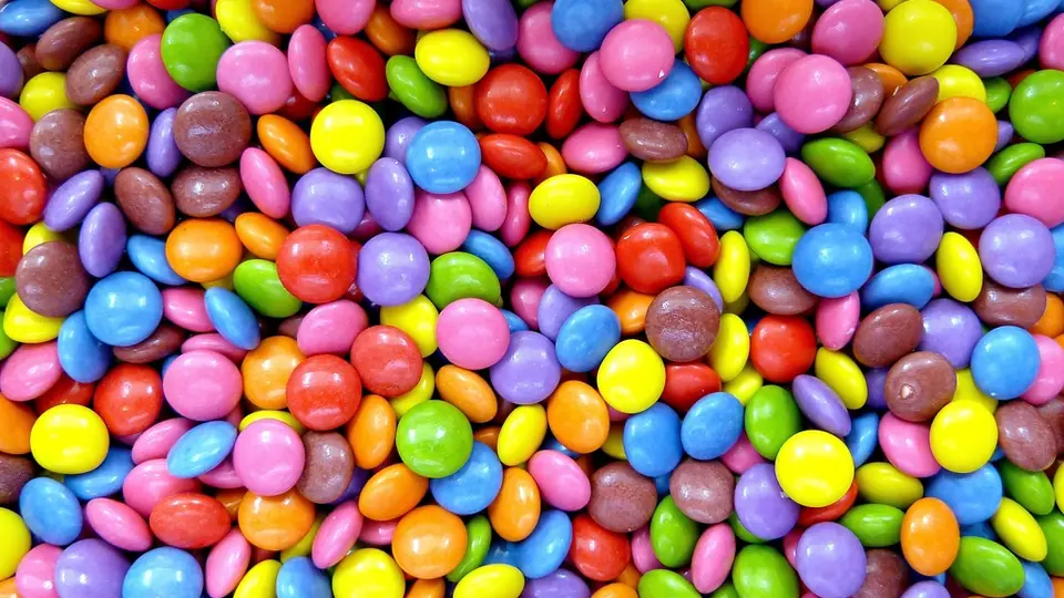 Dicht an dicht liegende bunte Schokolinsen in vielen Farben