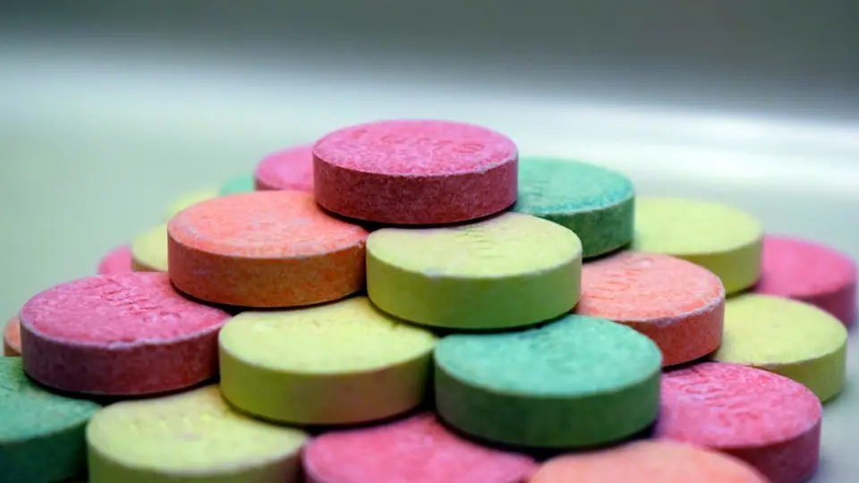 Gestapelte Traubenzucker-Täfelchen in Rosa, Grün und Gelb